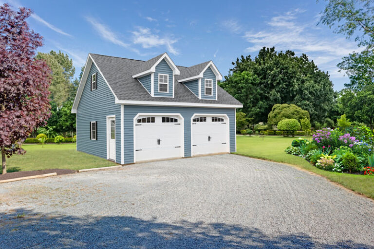 Blue and white custom Amish built garage and perfectly manicured lawn.