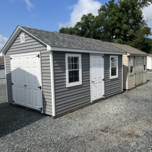 A grey storage shed with white trim