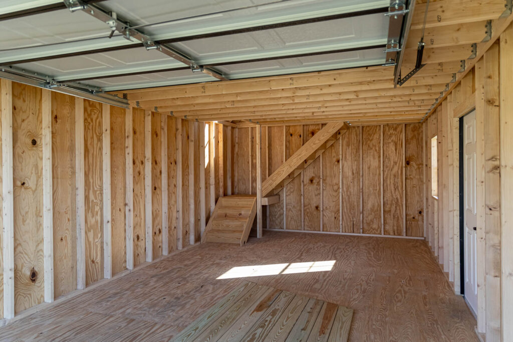interior of first floor in chalet garage shed shwoing stairs to second floor