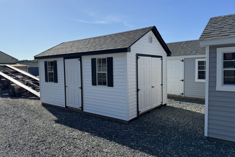 Black and white storage shed being unloaded on sales lot in Denton, MD