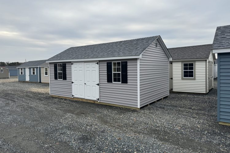 Gray and white storage shed with black shutters for sale in Denton, MD